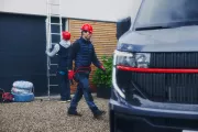 Renault Trucks Master Red EDITION Exclusive – van in the courtyard of a detached house with tradesmen installing solar panels – lifestyle