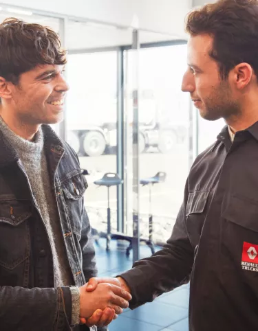 A customer and a mechanic shaking hands